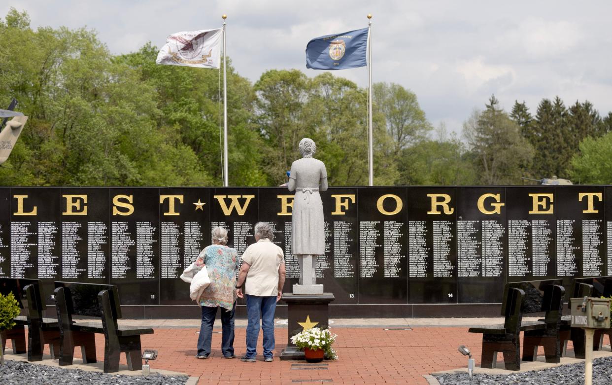 Visitors read the names of the 3,095 Ohioans who gave their lives in service to the country during the Vietnam War. The names are engraved on a wall at the Ohio Veterans' Memorial Park in Clinton.
