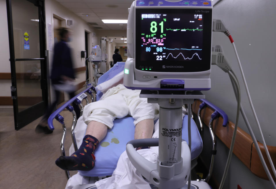 APPLE VALLEY, CALIFORNIA - JANUARY 05:  A patient lies on a stretcher in a hallway in the overloaded Emergency Room at Providence St. Mary Medical Center amid a surge in COVID-19 patients in Southern California on January 5, 2021 in Apple Valley, California. California has issued a new directive ordering hospitals with space to accept patients from other hospitals which have run out of ICU beds due to the coronavirus pandemic. The order could result in patients being shipped from Southern California to Northern California as Southern California continues to have zero percent of its remaining ICU (Intensive Care Unit) bed capacity. (Photo by Mario Tama/Getty Images)