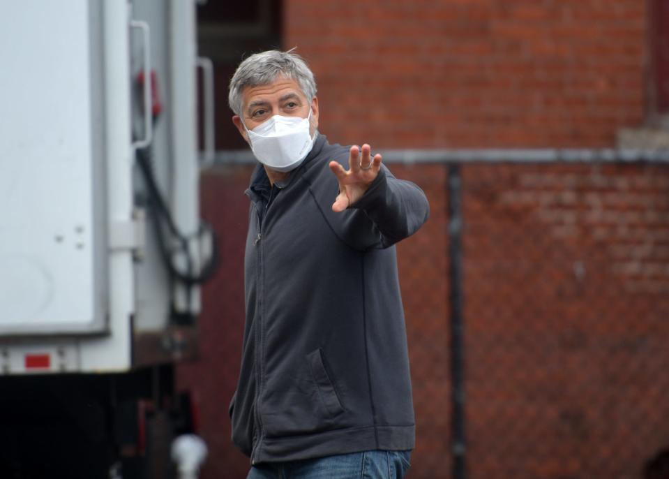 George Clooney waves hello as he enters the set of "The Tender Bar" at the old Commerce High School in Worcester in April.