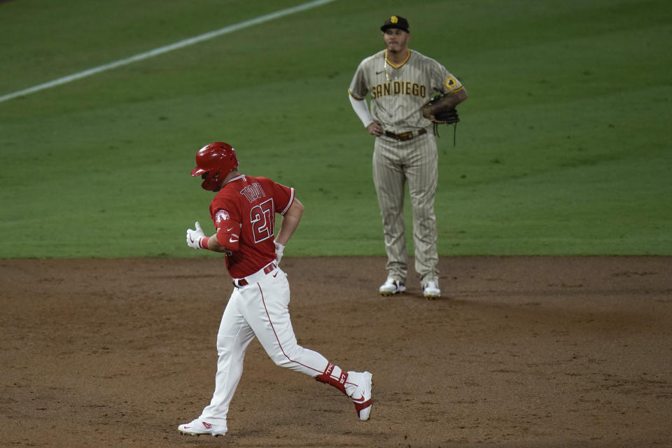 Los Angeles Angels' Mike Trout, front, rounds the bases past San Diego Padres third baseman Manny Machado after hitting a two-run home run during the third inning of a baseball game, Wednesday, Sept. 2, 2020, in Anaheim, Calif. (AP Photo/Jae C. Hong)