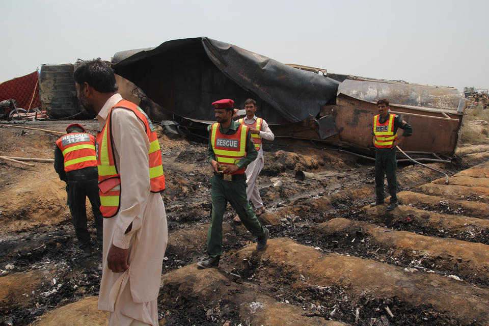 <p>Pakistani rescue workers gather beside an oil tanker which caught fire following an accident on a highway near the town of Ahmedpur East, some 670 kilometres (416 miles) from Islamabad on June 25, 2017.<br> (Ss Mirza/AFP/Getty Images) </p>