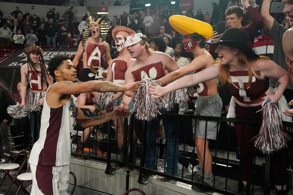 Mississippi State guard Shakeel Moore, left, is congratulated by the student section following the team's win over TCU in an NCAA college basketball game in Starkville, Miss., Saturday, Jan. 28, 2023. (AP Photo/Rogelio V. Solis)