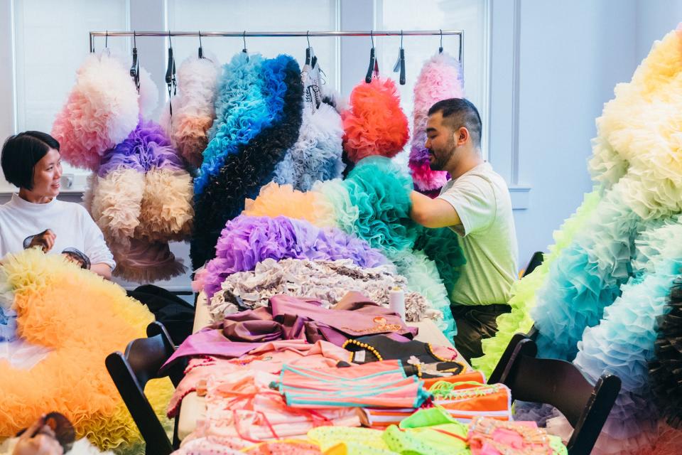 Koizumi and an assistant work on his dresses.