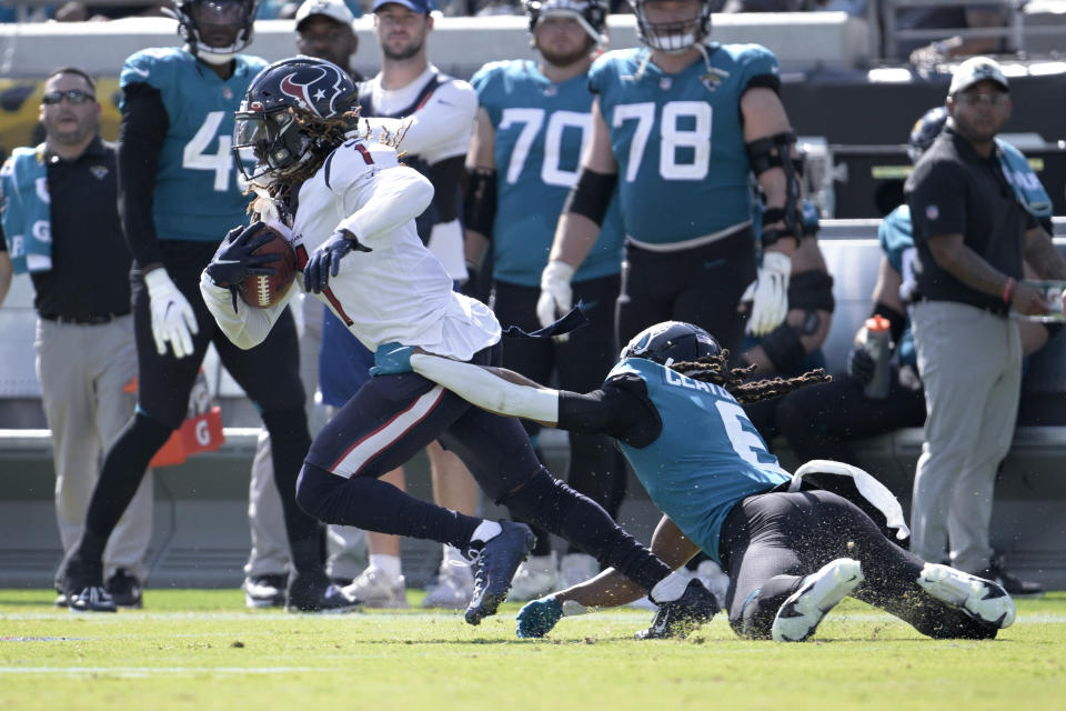 Houston Texans defensive back Tremon Smith (1) tries to break the tackle of Jacksonville Jaguars cornerback Chris Claybrooks (6) during the second half of an NFL football game in Jacksonville, Fla., Sunday, Oct. 9, 2022. (AP Photo/Phelan M. Ebenhack)
