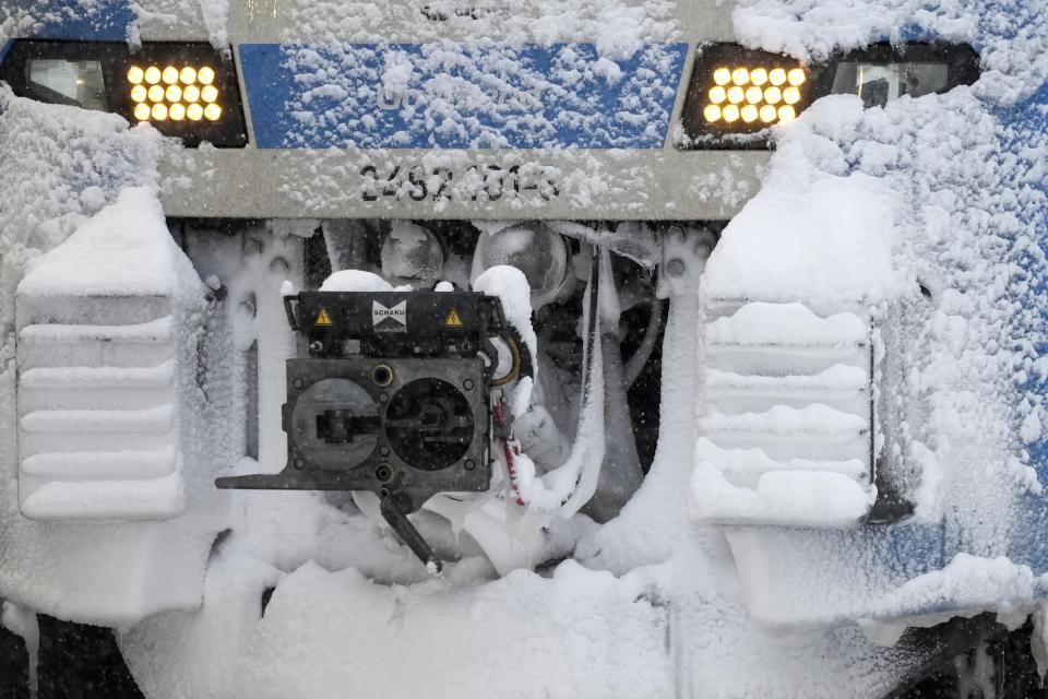 A snow covered regional train is parked at the central station after heavy snow fall in Munich, Germany, Saturday, Dec. 2, 2023. (AP Photo/Matthias Schrader)