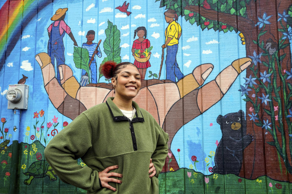 Kailani Taylor-Cribb stands in front of mural at a neighborhood community garden in Asheville, N.C., on Tuesday, Jan. 31, 2023. She knows, looking back, that things could have been different. While she has no regrets about leaving high school, she says she might have changed her mind if someone at school had shown more interest and personal attention to her needs. “All they had to do was take action,” she said. “There were so many times they could have done something. And they did nothing.” (AP Photo/Kathy Kmonicek)