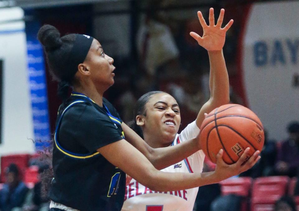 Delaware's Sydney Boone (left) tries to go the basket against Delaware State's Kiarra Mcelrath in the first half of Delaware State's 69-66 win at Memorial Hall in Dover, Thursday, Dec. 21, 2023.