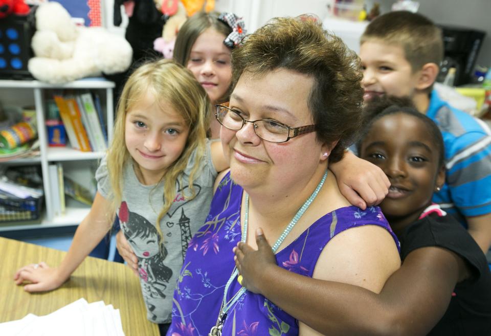 Volunteer Jennifer Danylczuk helps first graders (from left, Lilliana Terell, Gracie Thornton and Angel Maxwell) with math problems at R.L. Ward-Highlands Elementary School on May 18, 2015.