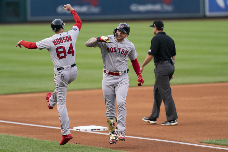 Boston Red Sox's Alex Verdugo, right, celebrates with third base coach Carlos Febles, left, after hitting a home run against the Washington National during the first inning of a baseball game Tuesday, Aug. 15, 2023, in Washington. (AP Photo/Stephanie Scarbrough)
