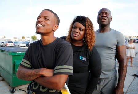 Family members try to spot a relative aboard the Bahamas Paradise Cruise Line ship, Grand Celebration, as it makes its way into port in Riviera Beach