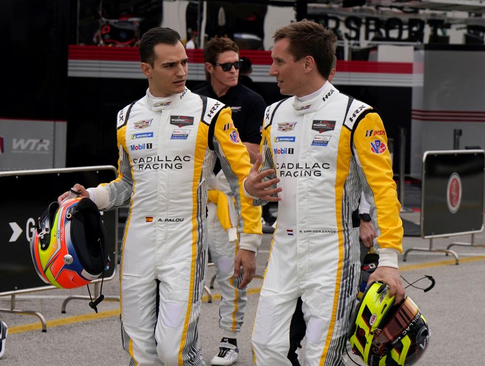 Alex Palou (left) with Cadillac co-driver Renger van der Zande in Daytona's garage area during Rolex 24 test weekend. Teammate Scott Dixon is in the background.