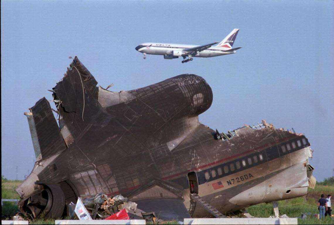 A Delta plane flies by the wreckage of Delta Flight 191 the day after the Aug. 2, 1985, crash.