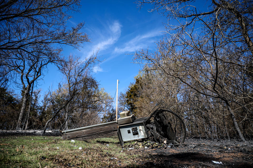 A downed power line and breaker box is pictured Saturday at the home of Margie Clark after a wildfire in Logan County near Guthrie.