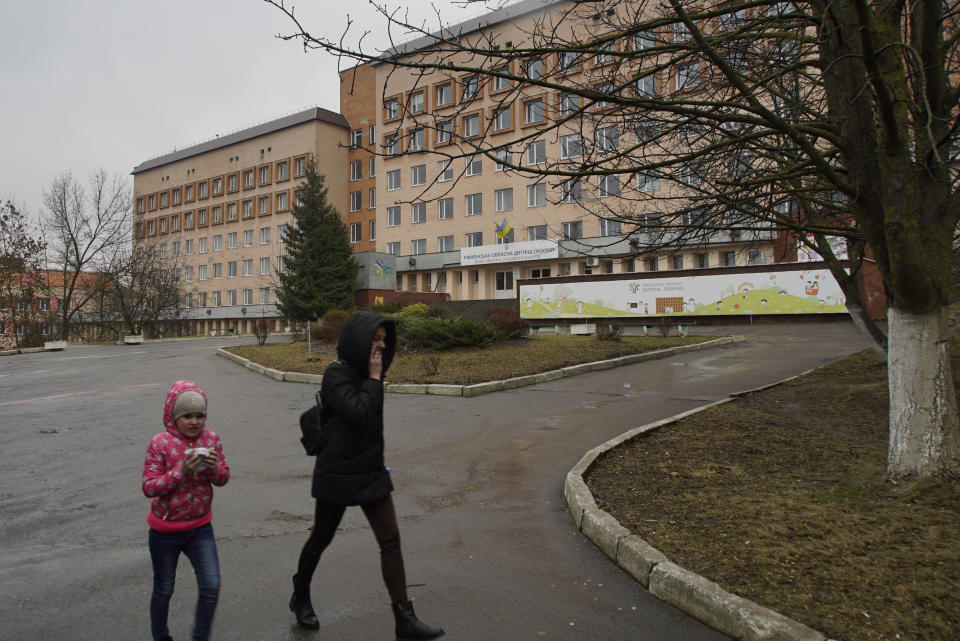 Mother and daughter walk away from the Rivne Regional Children's Hospital, in Rivne, Ukraine, on March 14, 2019. As Ukrainians prepare to go to the polls in a presidential election March 31, millions of Ukrainians have already voted with their feet by leaving the country, seemingly mired in corruption, poverty and conflict. (AP Photo/Mstyslav Chernov)