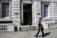 A police officer patrols in front of the cabinet office as British Prime Minister Boris Johnson is in intensive care fighting the coronavirus in London, Tuesday, April 7, 2020. Johnson was admitted to St Thomas' hospital in central London on Sunday after his coronavirus symptoms persisted for 10 days. Having been in hospital for tests and observation, his doctors advised that he be admitted to intensive care on Monday evening. The new coronavirus causes mild or moderate symptoms for most people, but for some, especially older adults and people with existing health problems, it can cause more severe illness or death.(AP Photo/Alberto Pezzali)