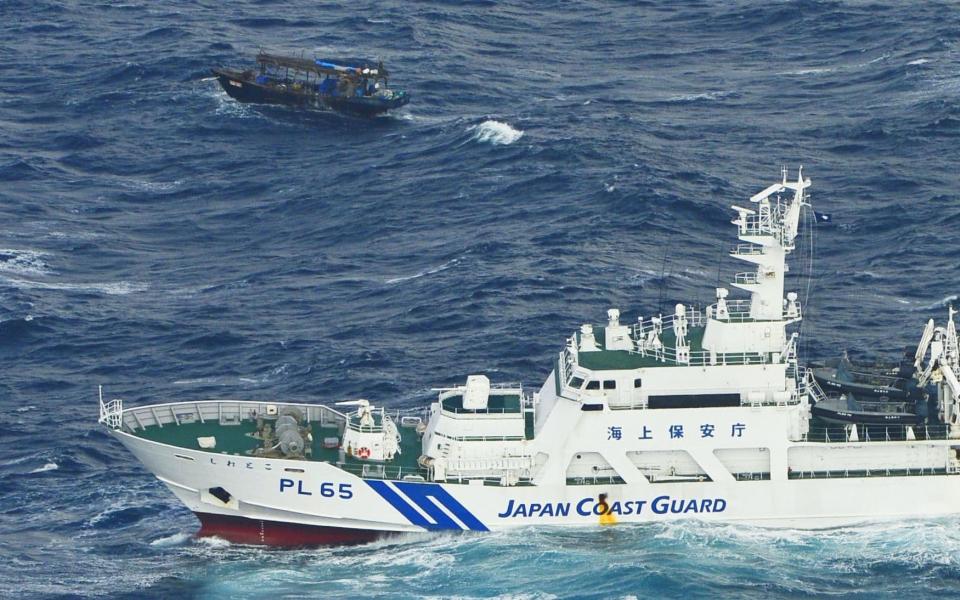 A North Korean wooden boat is seen near a patrol ship of Japan Coast Guard. off Matsumae town, Hokkaido northern Japan