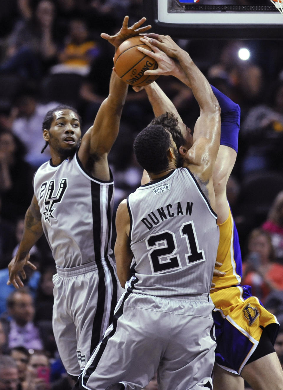 San Antonio Spurs' Kawhi Leonard, left, and Tim Duncan defend Los Angeles Lakers center Pau Gasol of Spain during the first half of an NBA basketball game Friday, March 14, 2014. (AP Photo/Bahram Mark Sobhani)