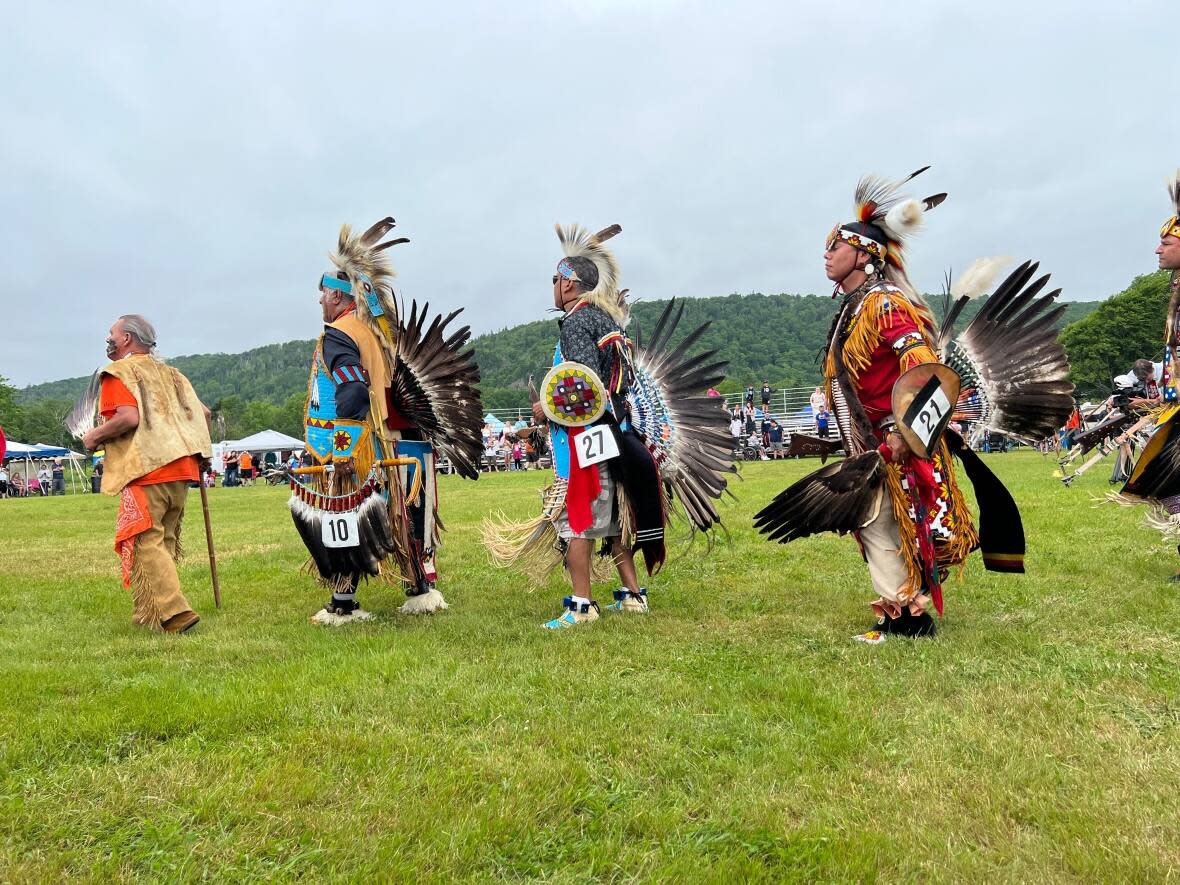 Elder dancers dressed in regalia enter the powwow grounds in the opening ceremony.   (Emily Latimer - image credit)