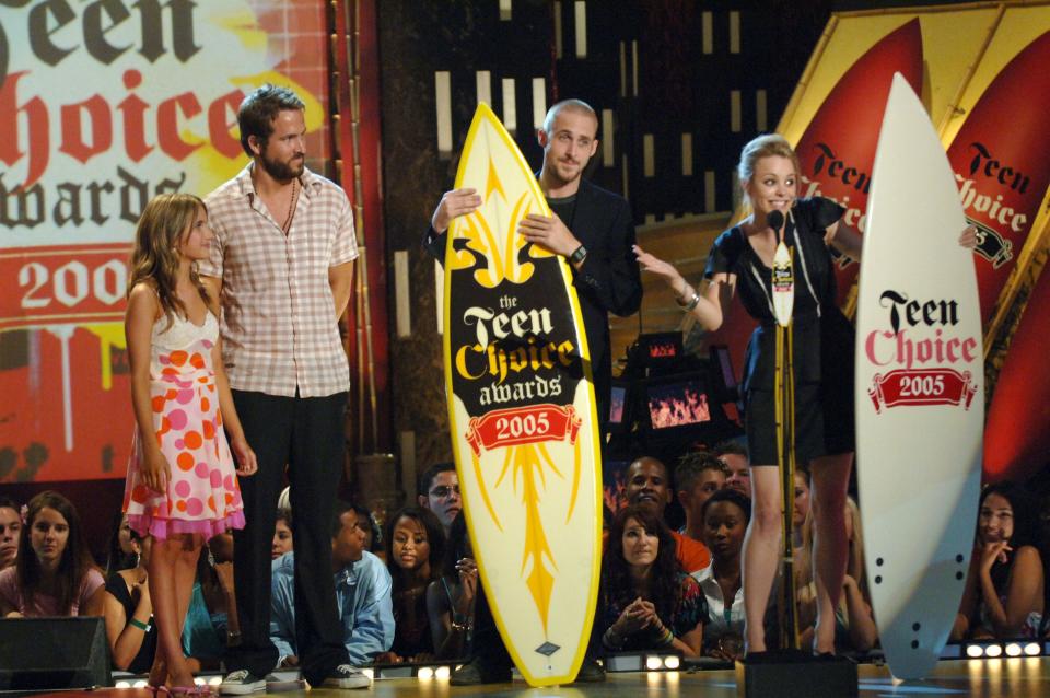Ryan Gosling and Rachel McAdams holding surfboard awards next to Ryan Reynolds