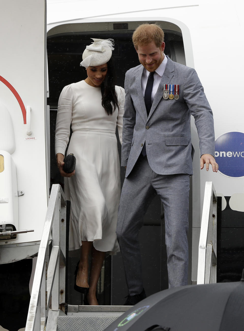 Britain's Prince Harry and Meghan, Duchess of Sussex disembark from their plane on their arrival in Suva, Fiji, Tuesday, Oct. 23, 2018. Prince Harry and his wife Meghan are on day eight of their 16-day tour of Australia and the South Pacific.(AP Photo/Kirsty Wigglesworth,Pool)