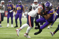 Minnesota Vikings wide receiver Justin Jefferson (18) catches a 6-yard touchdown pass ahead of New England Patriots linebacker Jahlani Tavai during the first half of an NFL football game, Thursday, Nov. 24, 2022, in Minneapolis. (AP Photo/Bruce Kluckhohn)