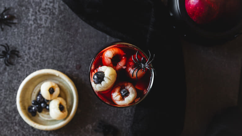 Overhead view of sangria pitcher with spider alongside sangria eyeballs