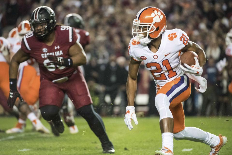 Clemson running back Darien Rencher (21) carries the ball against South Carolina defensive lineman Taylor Stallworth (90) during the first half of an NCAA college football game Saturday, Nov. 25, 2017, in Columbia, S.C. (AP Photo/Sean Rayford)