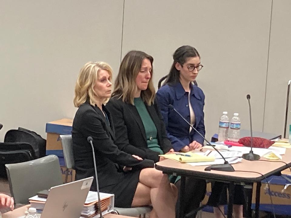 Dr. Caitlin Bernard, center, reacts as Indiana's medical licensing board finds she committed three privacy violations in the case of a 10-year-old rape victim.