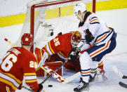 Edmonton Oilers winger Jesse Puljujarvi, right, has the net blocked by Calgary Flames goalie Jacob Markstrom during the second period of Game 5 of an NHL hockey second-round playoff series Thursday, May 26, 2022, in Calgary, Alberta. (Jeff McIntosh/The Canadian Press via AP)