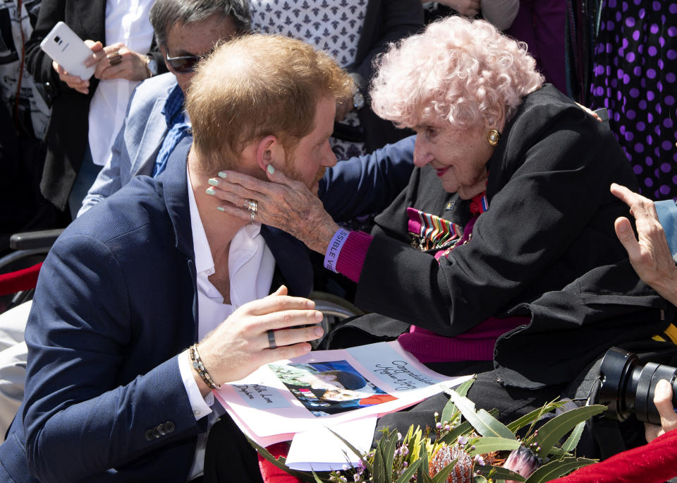 Britain's Prince Harry is embraced by 98-year-old Daphne Dunne during a walkabout outside the Opera House in Sydney, Australia, Tuesday, Oct. 16, 2018. (Paul Edwards/Pool Photo via AP)