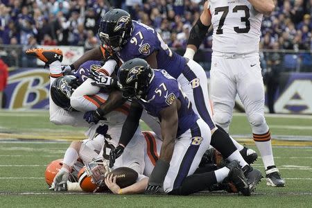 Dec 28, 2014; Baltimore, MD, USA; Cleveland Browns quarterback Connor Shaw (9) is sacked by Baltimore Ravens outside linebacker Terrell Suggs (55), defensive end Timmy Jernigan (97) and inside linebacker C.J. Mosley (57) during the second quarter at M&T Bank Stadium. Mandatory Credit: Tommy Gilligan-USA TODAY Sports