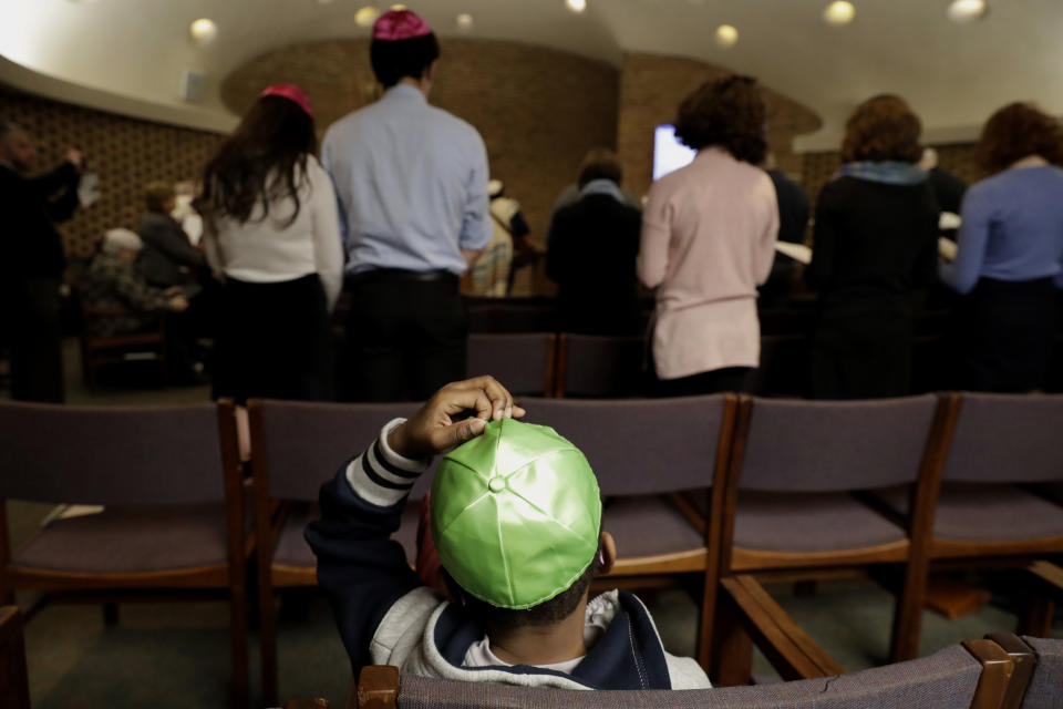 In this Jan. 17, 2020, photo Matam Berger-Gould, checks his yamaka (green) during the Friday Shabbat Service at KAM Isaiah Israel in Chicago. On the eve of the day set aside to honor an African American who strove against hate and preached racial and social justice, some worry the nation is becoming more divided. (AP Photo/Nam Y. Huh)