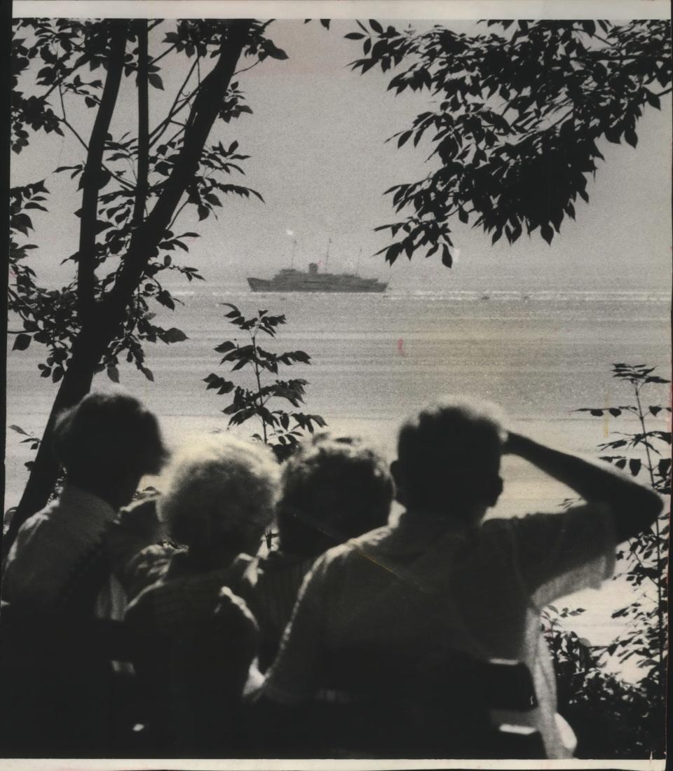 Framed in the trees along the bluff on North Wahl Avenue, the British royal yacht Britannia passed in view of spectators seated on a park bench in Milwaukee's Lake Park on July 7, 1959. Queen Elizabeth reportedly missed the view; she was sleeping.