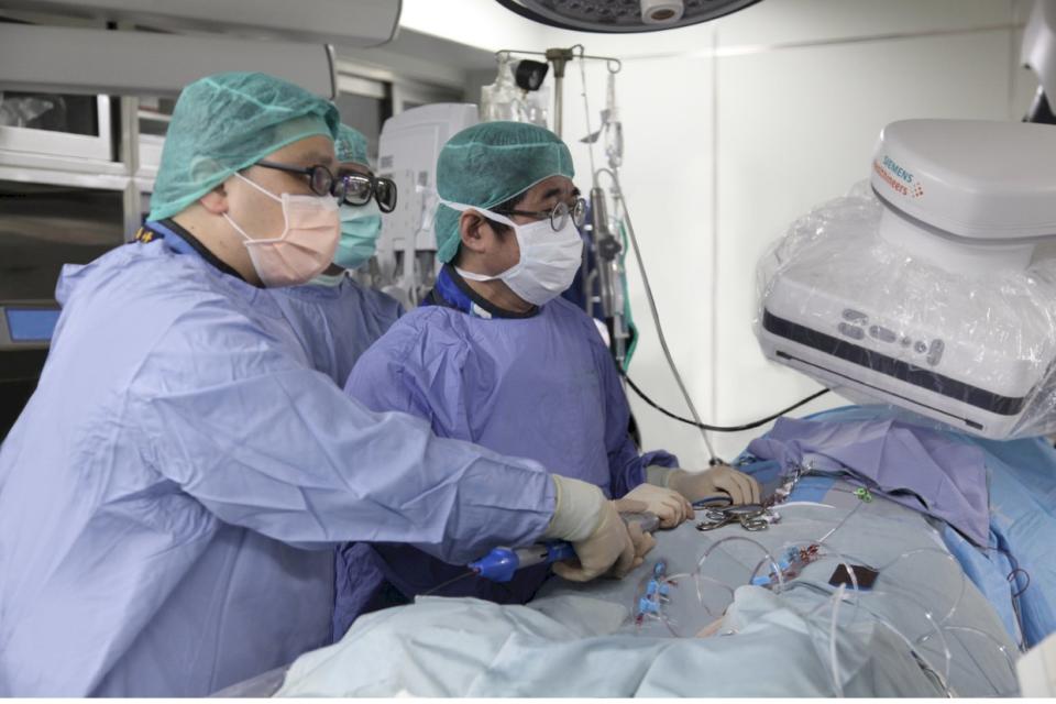 國泰醫院心血管中心部副主任黃啟宏 (右)執行「經導管主動脈瓣膜置換手術(TAVI)」。(國泰醫院提供)