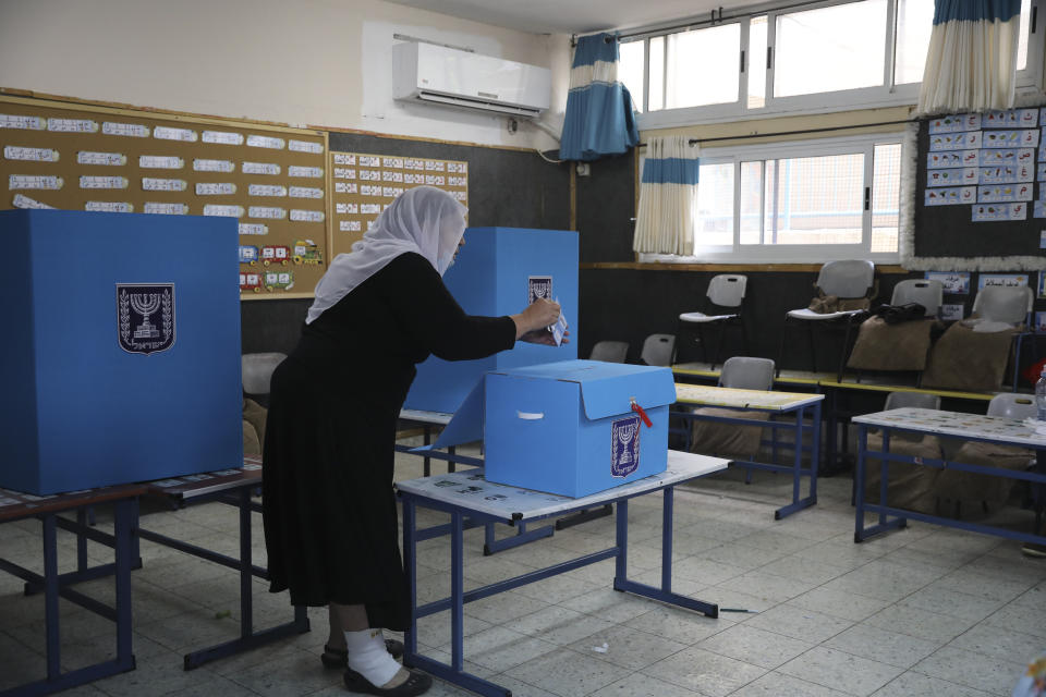 An Israeli Arab woman votes for Israel's parliamentary election at a polling station in Maghar, Israel, Tuesday, March. 23, 2021. Israel is holding its fourth election in less than two years. (AP Photo/Mahmoud Illean)