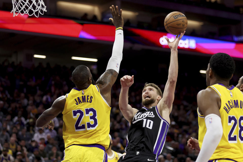 Sacramento Kings forward Domantas Sabonis (10) shoots against Los Angeles Lakers forward LeBron James (23) during the second half of an NBA basketball game in Sacramento, Calif, Wednesday, March 13, 2024. (AP Photo/Jed Jacobsohn)