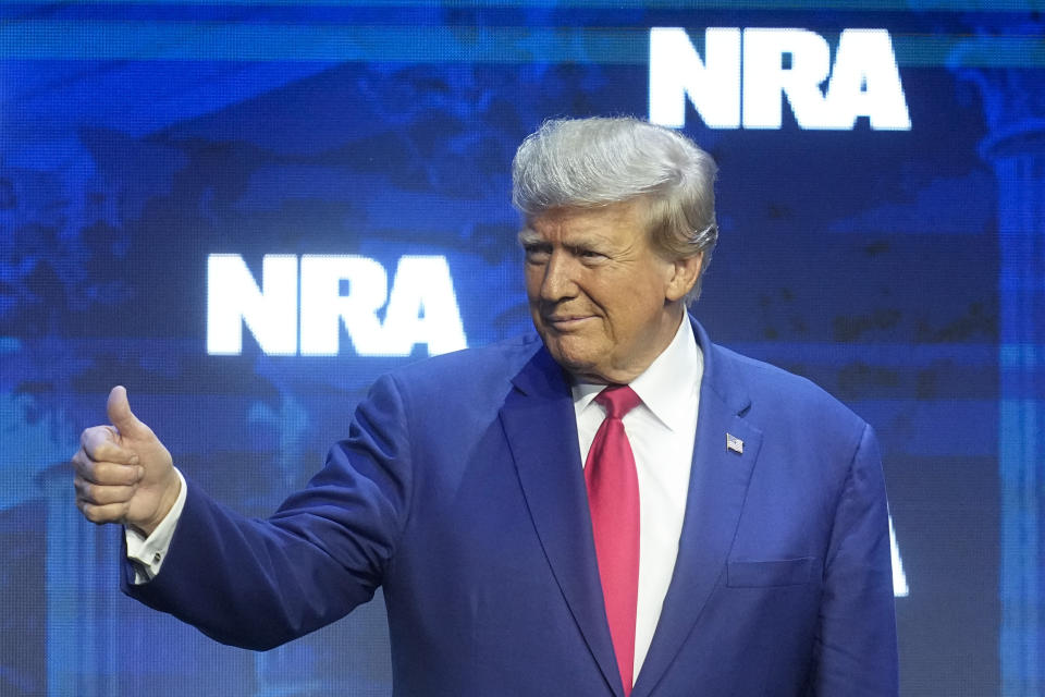 Former President Donald Trump reacts to the crowd before speaking during the National Rifle Association Convention, Friday, April 14, 2023, in Indianapolis. (AP Photo/Darron Cummings)