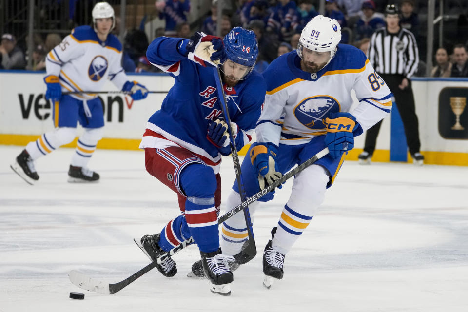 Buffalo Sabres right wing Alex Tuch (89) and New York Rangers center Tyler Motte (14) battle for the puck during the second period of an NHL hockey game, Monday, April 10, 2023, in New York. (AP Photo/John Minchillo)