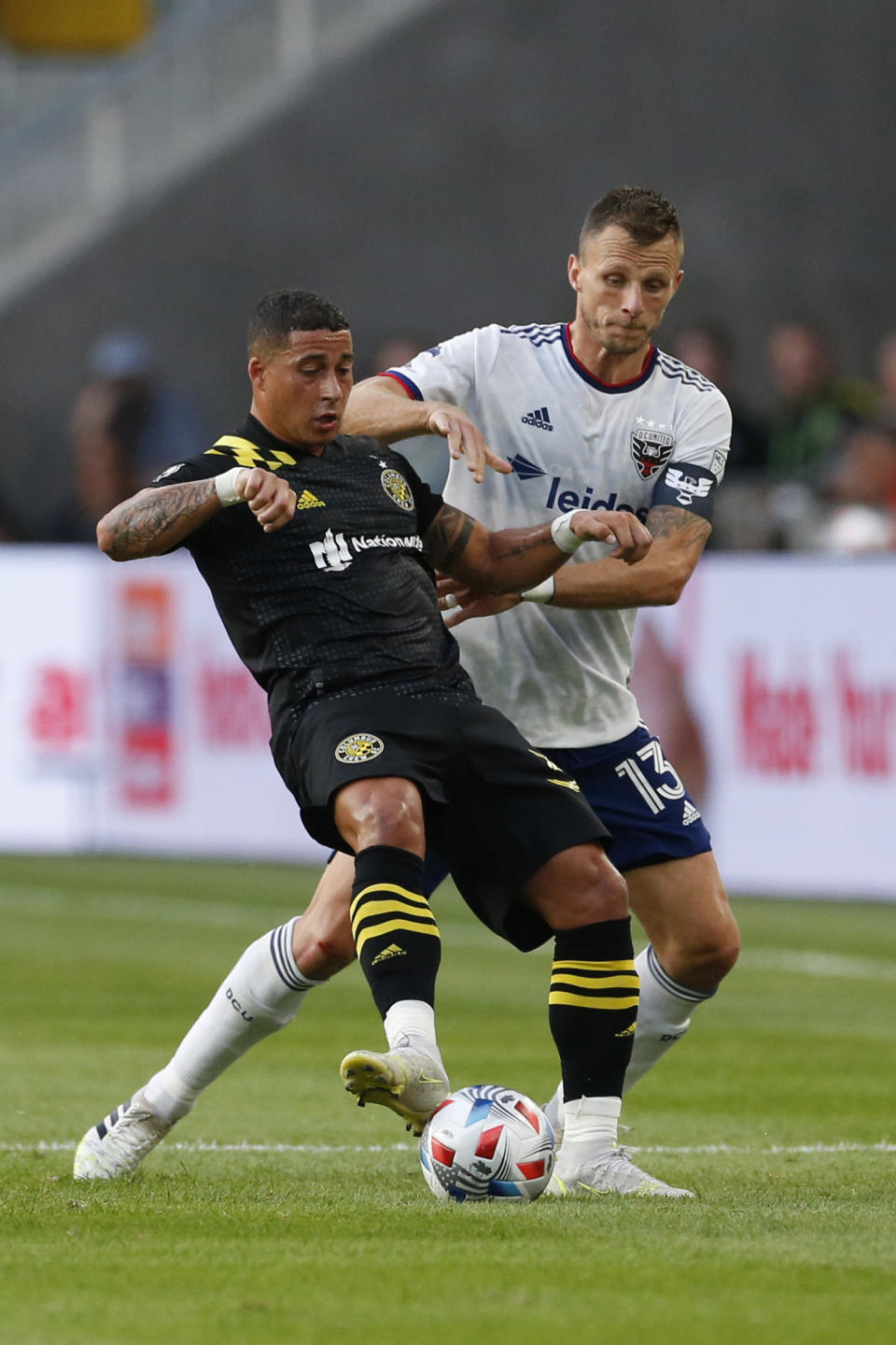 Columbus Crew's Erik Hurtado, left, and D.C. United's Frederic Brillant vie for the ball during the first half of an MLS soccer match Wednesday, Aug. 4, 2021, in Columbus, Ohio. (AP Photo/Jay LaPrete)