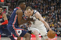 Utah Jazz guard Joe Ingles (2) drives around Washington Wizards center Thomas Bryant, left, in the first half during an NBA basketball game Friday, Feb. 28, 2020, in Salt Lake City. (AP Photo/Rick Bowmer)