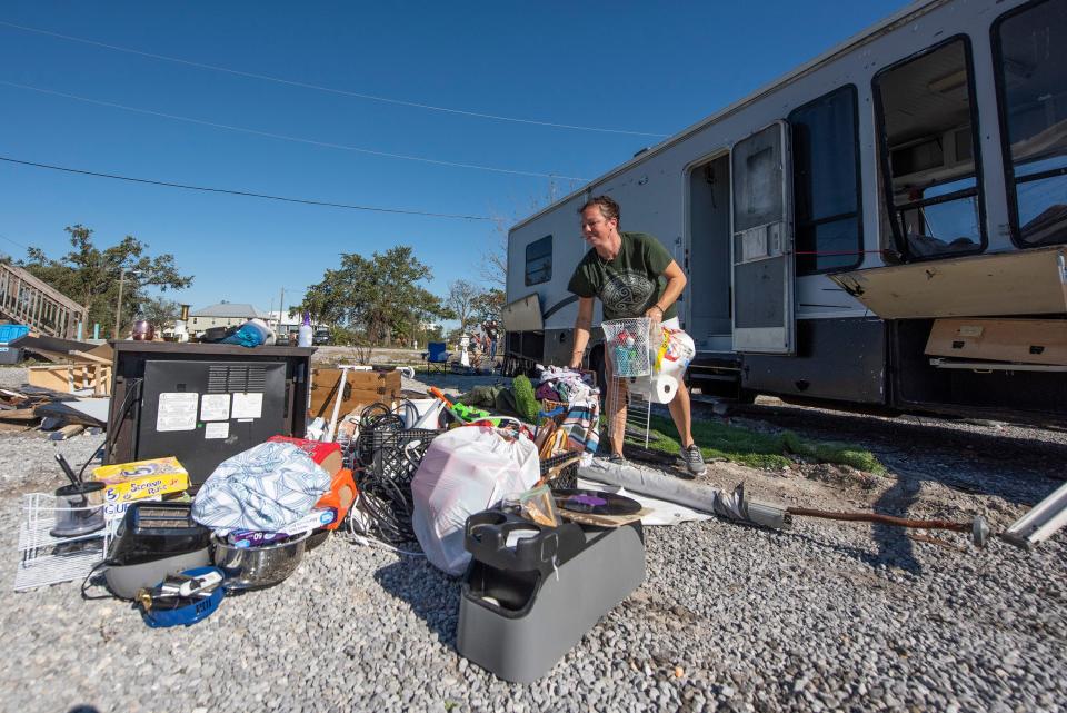 Amanda Underwood sorts through belongings Oct. 19, 2020, after the RV her family lived in at Gulf Haven RV Resort in Gulfport, Miss., overturned when Hurricane Zeta hit the area.