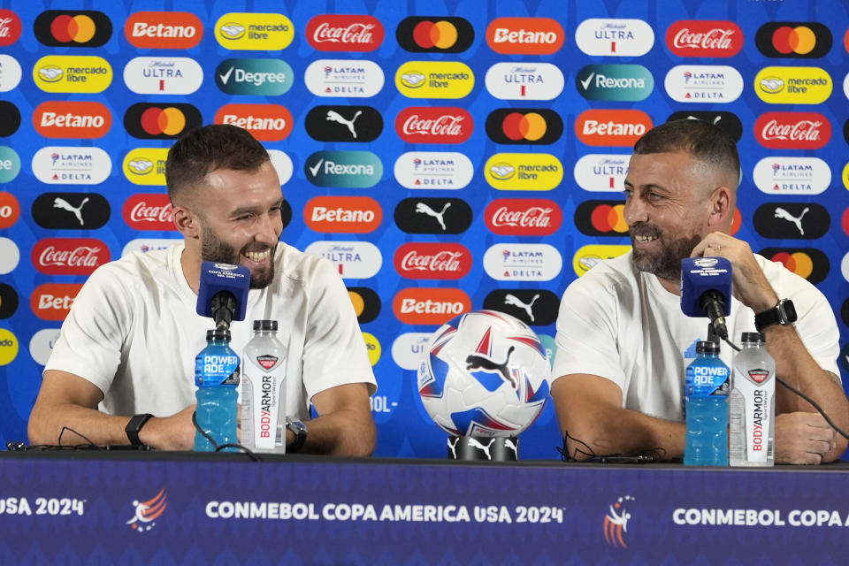 El zaguero Germán Pezzella (izquierda) y el entrenador asistente Walter Samuel, de la selección de Argentina, sonríen en una conferencia de prensa, el viernes 28 de junio de 2024, en Miami Gardens, Florida (AP Foto/Lynne Sladky)