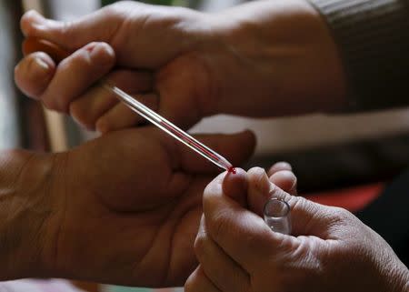 A doctor draws blood from a patient at her house in the village of Staiky, south of Kiev, Ukraine, November 11, 2015. REUTERS/Valentyn Ogirenko