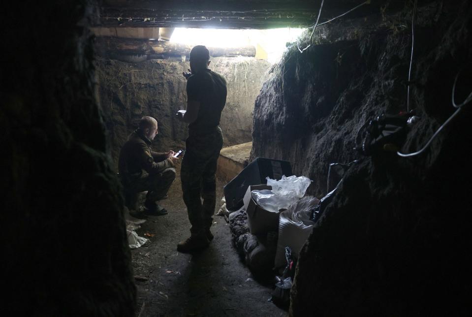 Two Ukrainian servicemen of the 10th Mountain Assault Brigade “Edelweiss” stand in a dugout trench near Bakhmut in the Donetsk region yesterday (AFP via Getty Images)
