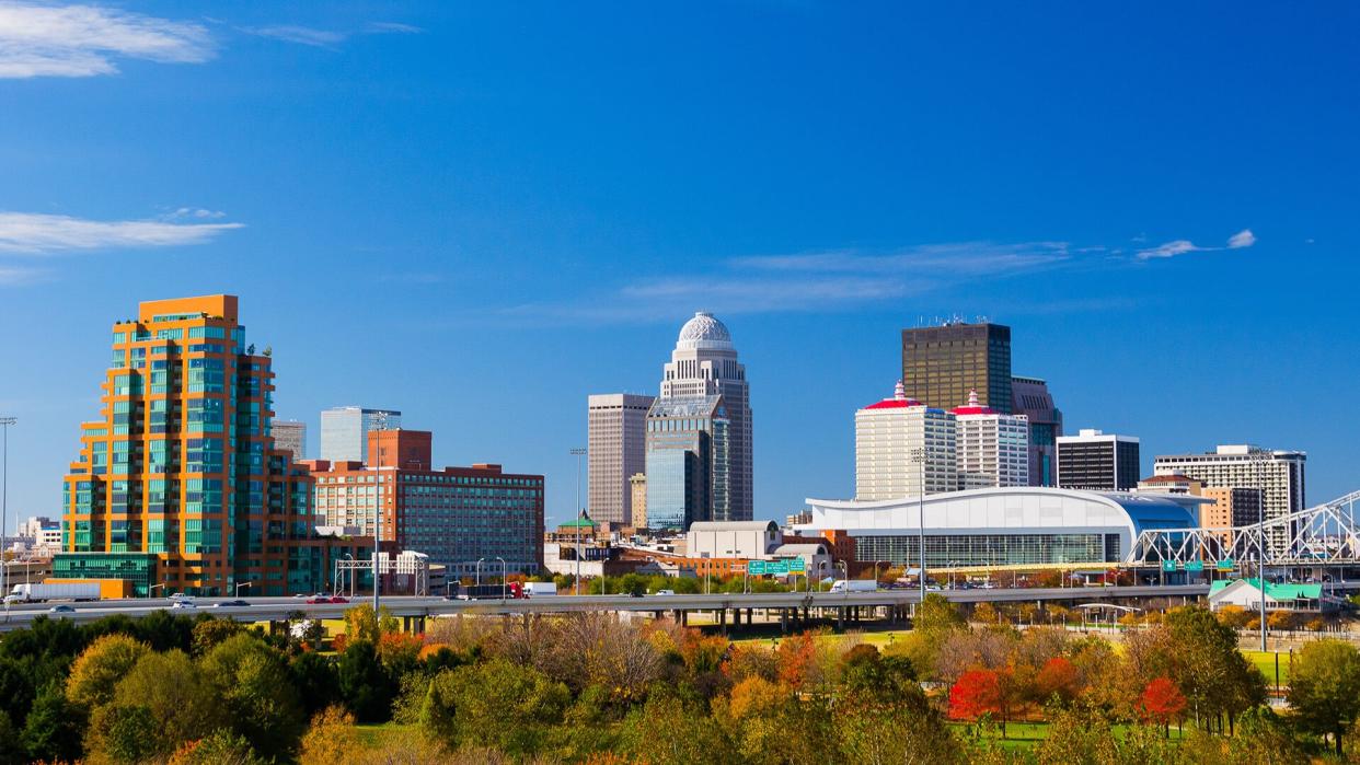 Louisville downtown skyline view with a park with trees in the foreground.