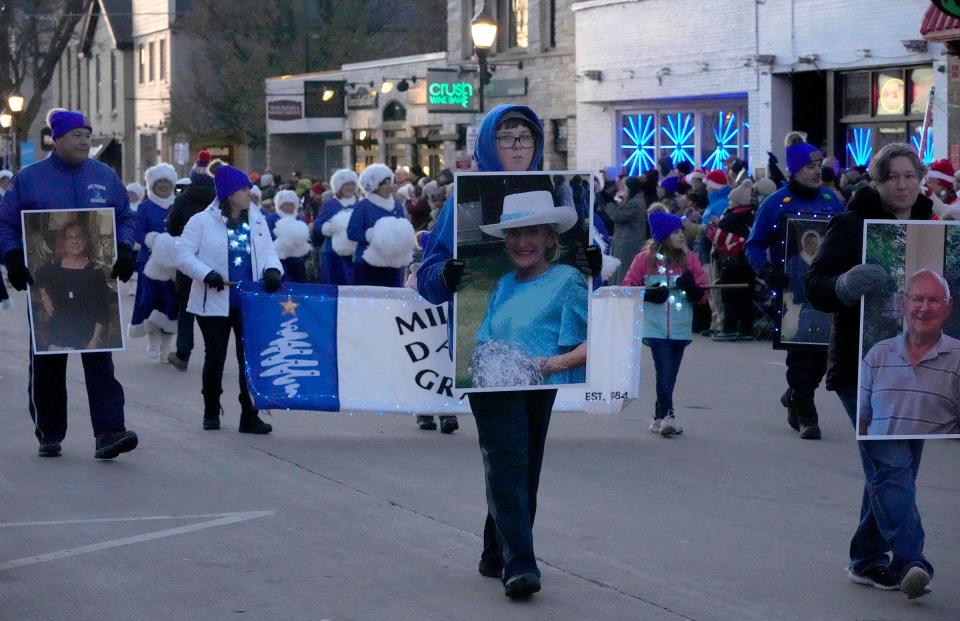 Family members of the Dancing Grannies held photos of their loved ones who died in last year’s parade attack, including, from left, Virginia Sorenson, Lee Owen and Bill Hospel, who volunteered with the Dancing Grannies, during the Waukesha Christmas Parade in downtown Waukesha on Sunday, Dec. 4, 2022. It’s the first Christmas parade in Waukesha since Darrell Brooks drove his SUV through the parade route in November 2021 killing six people and injuring more than 60 others.