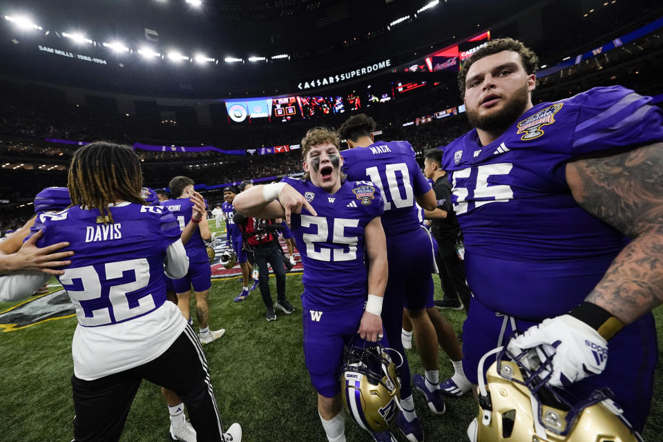 Washington players celebrate victory after the Sugar Bowl CFP NCAA semifinal college football game between Washington and Texas, Tuesday, Jan. 2, 2024, in New Orleans. Washington won 37-31. (AP Photo/Gerald Herbert)