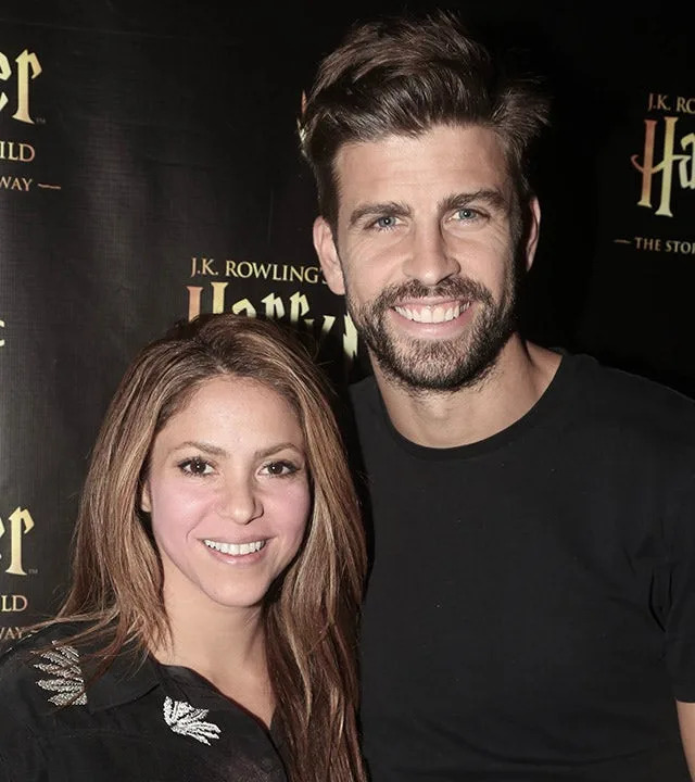 Shakira and Gerard Piqué both wearing black pose for a photo backstage at 