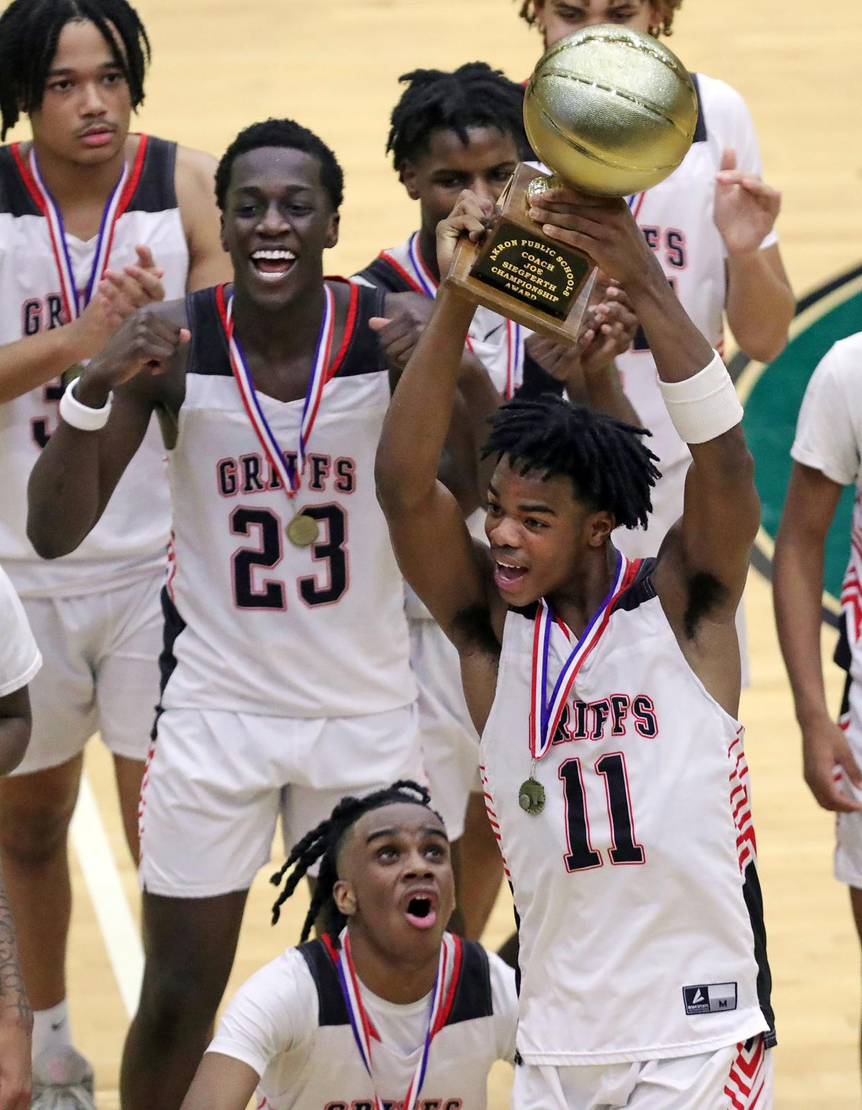 Buchtel's Moustapha Ndao (23), Diaire Pride Jr., (0) and Stevie Diamond (11) celebrate after beating Garfield in the City Series championship, Friday, Feb. 2, 2024.