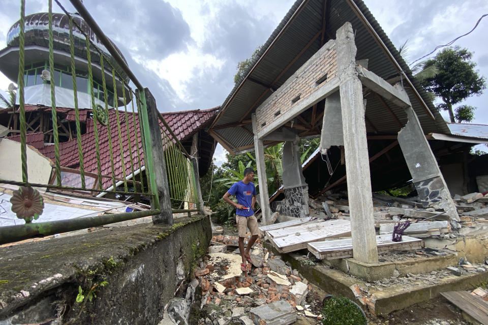 A man inspects damaged buildings following an earthquake in Talamau, West Sumatra, Indonesia, Friday, Feb. 25, 2022. The strong and shallow earthquake hit off the coast of Indonesia's Sumatra island on Friday, panicking people in Sumatra island and neighboring Malaysia and Singapore. (AP Photo/Suryo Wibowo)